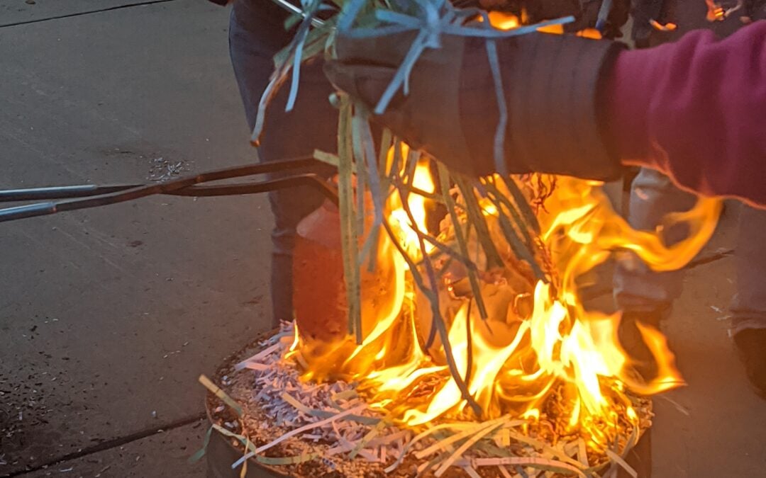 Flames surround a 1700 degree piece of pottery taken hot out of the kiln. This piece will be covered and allowed to smoke. This will produce high metallic lusters and rainbow effects.